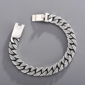 Macro shot of silver Cuban link bracelet with iced out pavé zircons and box clasp