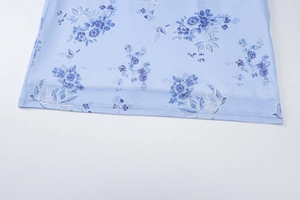 Detailansicht des hellblauen Kleidersaums mit Blumenmuster und hochwertiger Verarbeitun