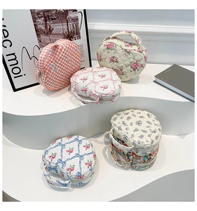 Multiple floral quilted heart pouches in various patterns on white display stands