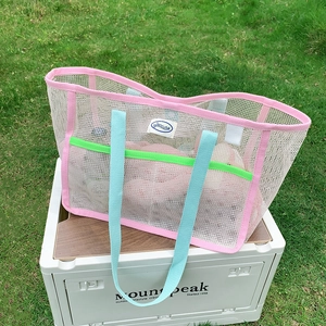 Detail of pink and green mesh beach bag on a camping box in an outdoor garden