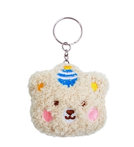 Close-up of beige plush bear keychain with soft faux lambswool texture and metal ring