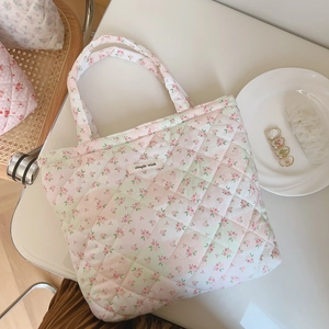 Close-up of pink floral quilted tote bag featuring a simple wish woven label and cotton texture