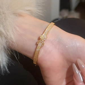 Detailed side view of a gold-plated bracelet with pavé cubic zirconia and double ring clasp