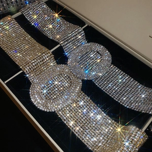 Detailed close-up of luxury gold and silver rhinestone studded necklaces in a black velvet box