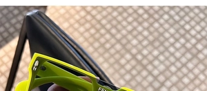 Detail of neon green square sunglasses featuring a thick frame and metal hinge design