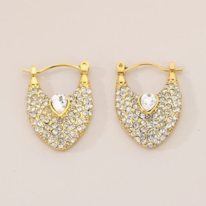 Détail macro de boucles d'oreilles vintage dorées avec strass et cristal en goutte