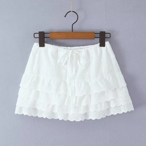 Détail de la jupe blanche à volants avec broderie ajourée et cordon de serrage