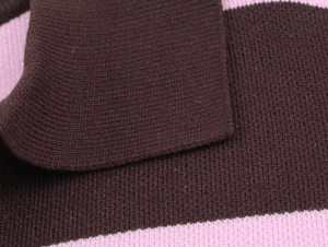 Dettaglio polo in maglia a coste con ampie strisce orizzontali marroni e rosa