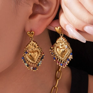 Boucles d'oreilles cœur vintage dorées avec pampilles en perles colorées sur mannequin