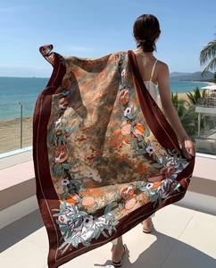 Detail of printed ethnic shawl featuring pomegranate motifs on a sunny beach balcony