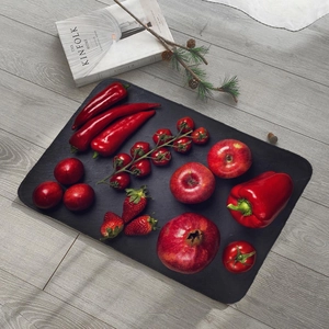 Absorbent fruit-themed flannel rug on grey wood floor with fresh red vegetables