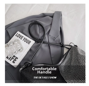 Detailed macro view of black rhinestone tote bag with knotted cylindrical leather handle