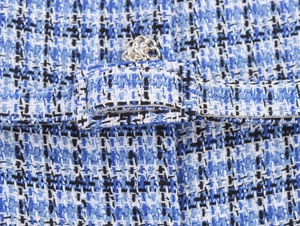 Gros plan sur la texture du tissu en tweed bleu avec un détail de boucle rectangulaire