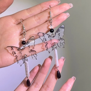 Detail of butterfly drop earrings with calligraphy print and white marble bead