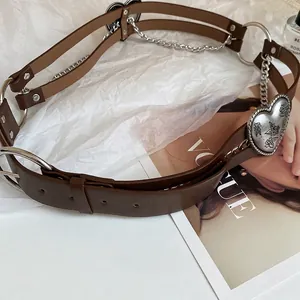 Vintage leather waist belt featuring a large engraved heart buckle and silver metal chains