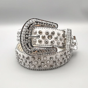 Macro detail of western white belt with silver studs, rhinestones, and embossed texture