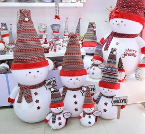 Macro detail of various sizes of plush Christmas snowmen with knitted hats and scarves