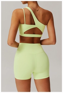 Detail of neon green one-shoulder sports bra and high-waist shorts set from the back view