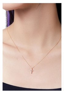 Close-up of 925 sterling silver 14k gold plated cross pendant with shimmering cubic zirconia