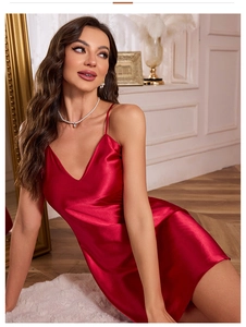 Detail of red satin slip nightdress featuring deep V-neck and silky texture finish