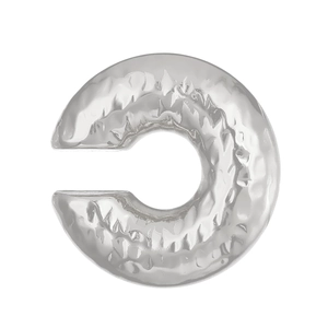 Detail of silver C-shape ear cuff showing unique hammered texture on metal surface