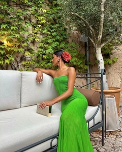 Detail of green strapless knit maxi dress with pleated texture on a sitting model