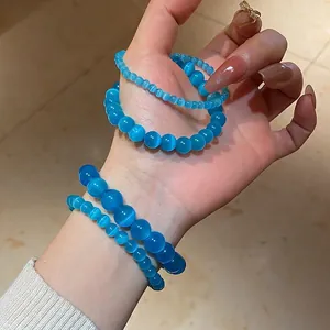 Deep blue cat eye stone beaded bracelet set showing layered wear on a female wrist