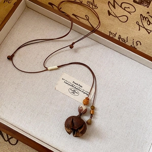 Close-up of vintage wax cord necklace with wood bead star pendant on a tray