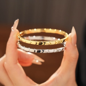 Macro shot of minimalist chevron textured bangles in polished gold and silver finishes