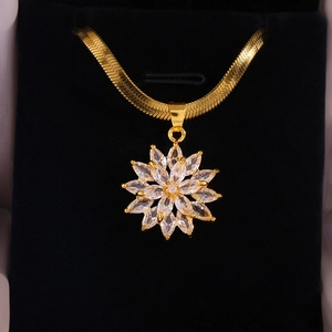 Macro shot of gold sunflower pendant with pave-set crystals on flat snake chain