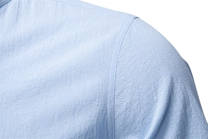 Close-up of light blue cotton linen shirt shoulder detail with reinforced stitching