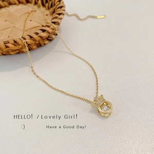 Elegant gold plated angel wing crown necklace with sparkling gems on a textured background
