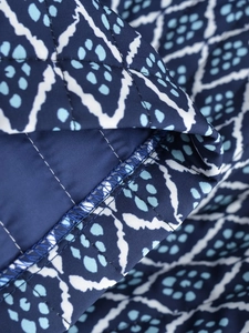 Macro close-up showing precision stitching and geometric patterns on quilted fabric