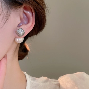 Macro view of luxury square cubic zirconia stud with elegant white pearl drop earring