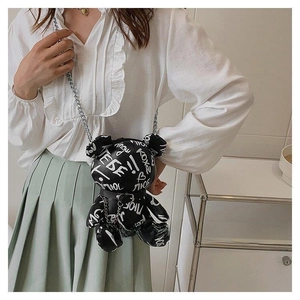 Detailed view of black graffiti bear crossbody bag with silver metal chain strap