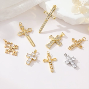 Retro zircon cross pendants with 14K gold plating and diamond accents on white fabric
