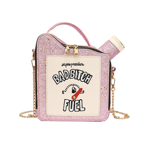 Detail of pink sequin oil drum handbag with gold chain strap and embroidered fuel patches
