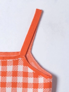 Detailed macro view of orange and white checkered knit top strap and neckline texture
