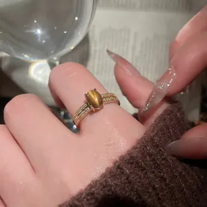 Vintage gold plated ring with oval tiger eye stone and micro-pave zircon on finger