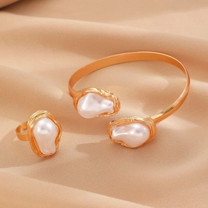 Macro detail of gold-plated bangle and adjustable ring with irregular baroque pearls