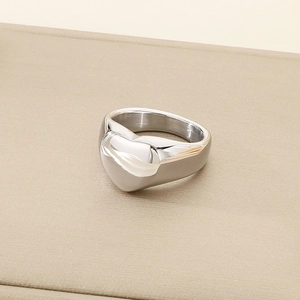 Close-up of heart-shaped polished silver steel ring with thick minimalist band