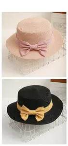 Detailed tile display of flat top straw hats with decorative striped ribbon bows