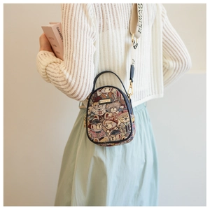 Detail of printed crossbody bag with wide shoulder strap and bear pattern on a model