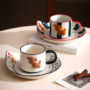 Detail of red and black ceramic coffee mug sets featuring 3D brown dog relief patterns