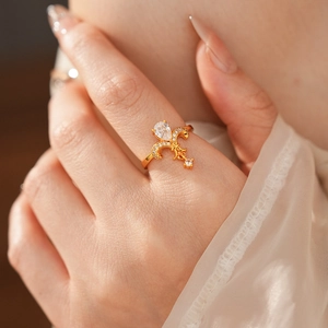 Detailed shot of a vintage gold fleur-de-lis ring with a pear-shaped zircon on a hand