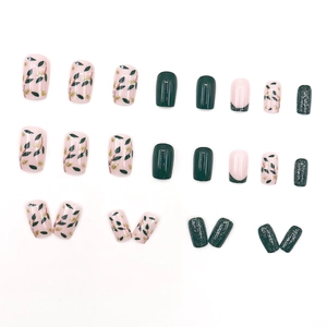Green press-on nails set with gold foil leaf patterns and emerald green glitter finish
