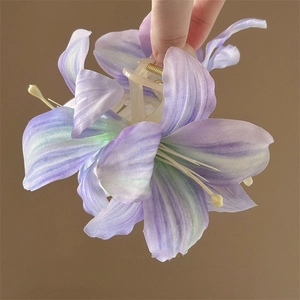 Close-up of purple gradient artificial lily flower hair claw clip with silk petals