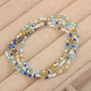 Macro view of multi-layered colorful glass beads in white gold and blue on a display tray