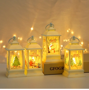Detail of four white Christmas LED lanterns with festive illustrations and warm light