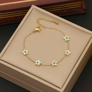 Detailed macro of gold-plated evil eye star charms on a stainless steel bracelet